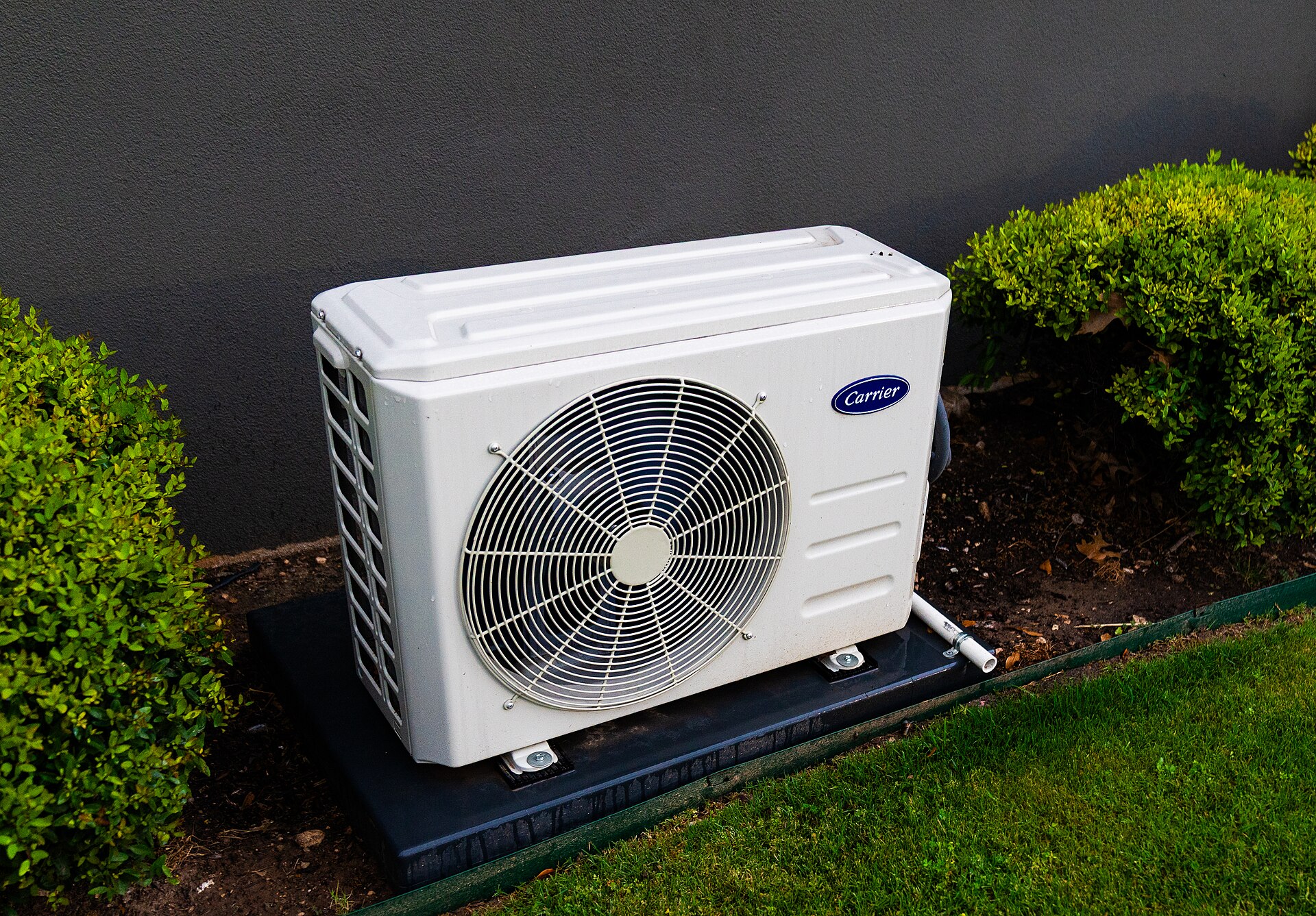 Unité extérieure de climatisation Carrier installée en jardin